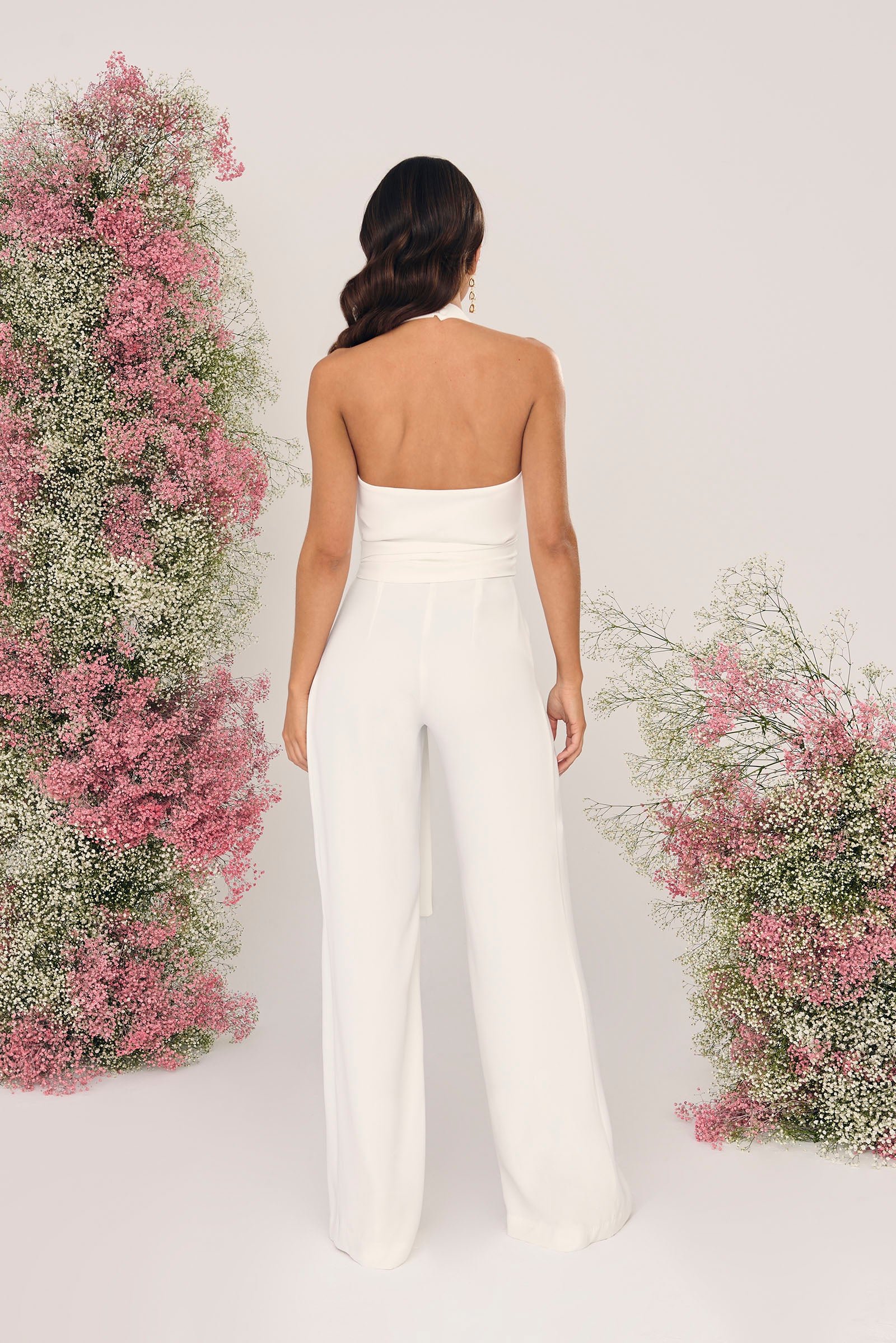 Mono de novia Astible en crepé blanco, con cuello halter, escote en V y pantalón de pata elefante