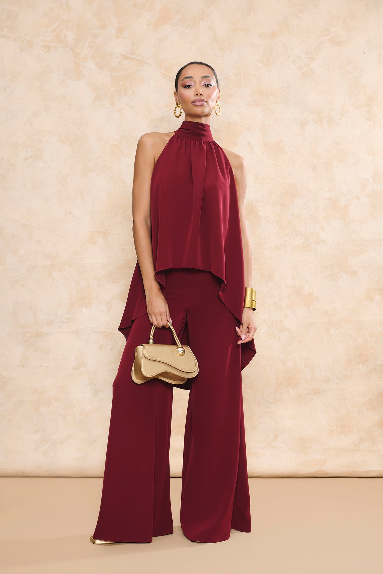 Conjunto Triana granate de pantalón de invitada palazzo y top halter asimétrico con caída fluida de Miphai.