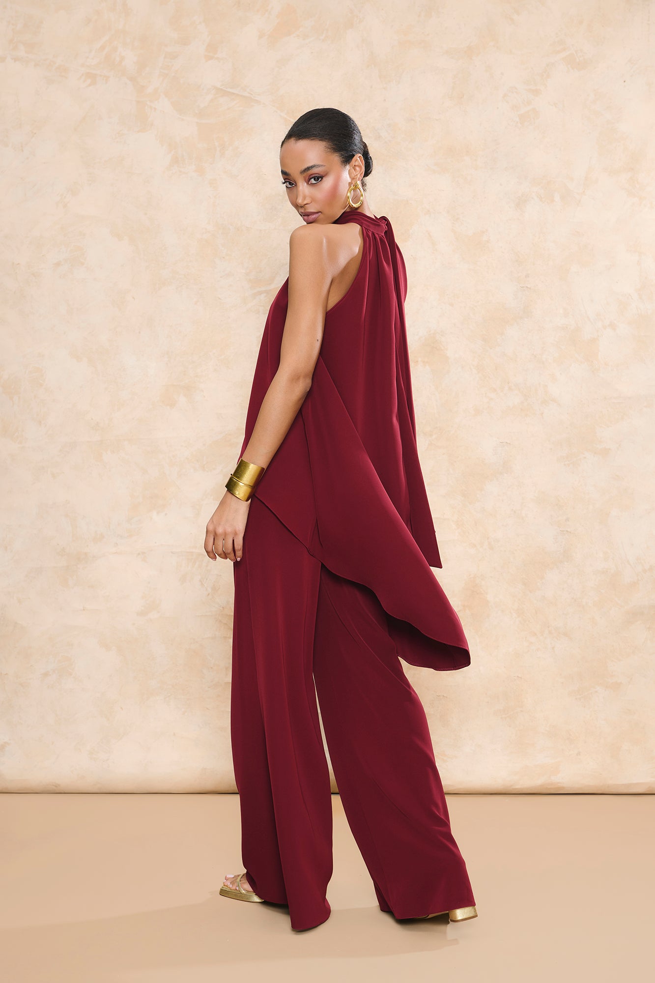 Conjunto Triana granate de pantalón de invitada palazzo y top halter asimétrico con caída fluida de Miphai.