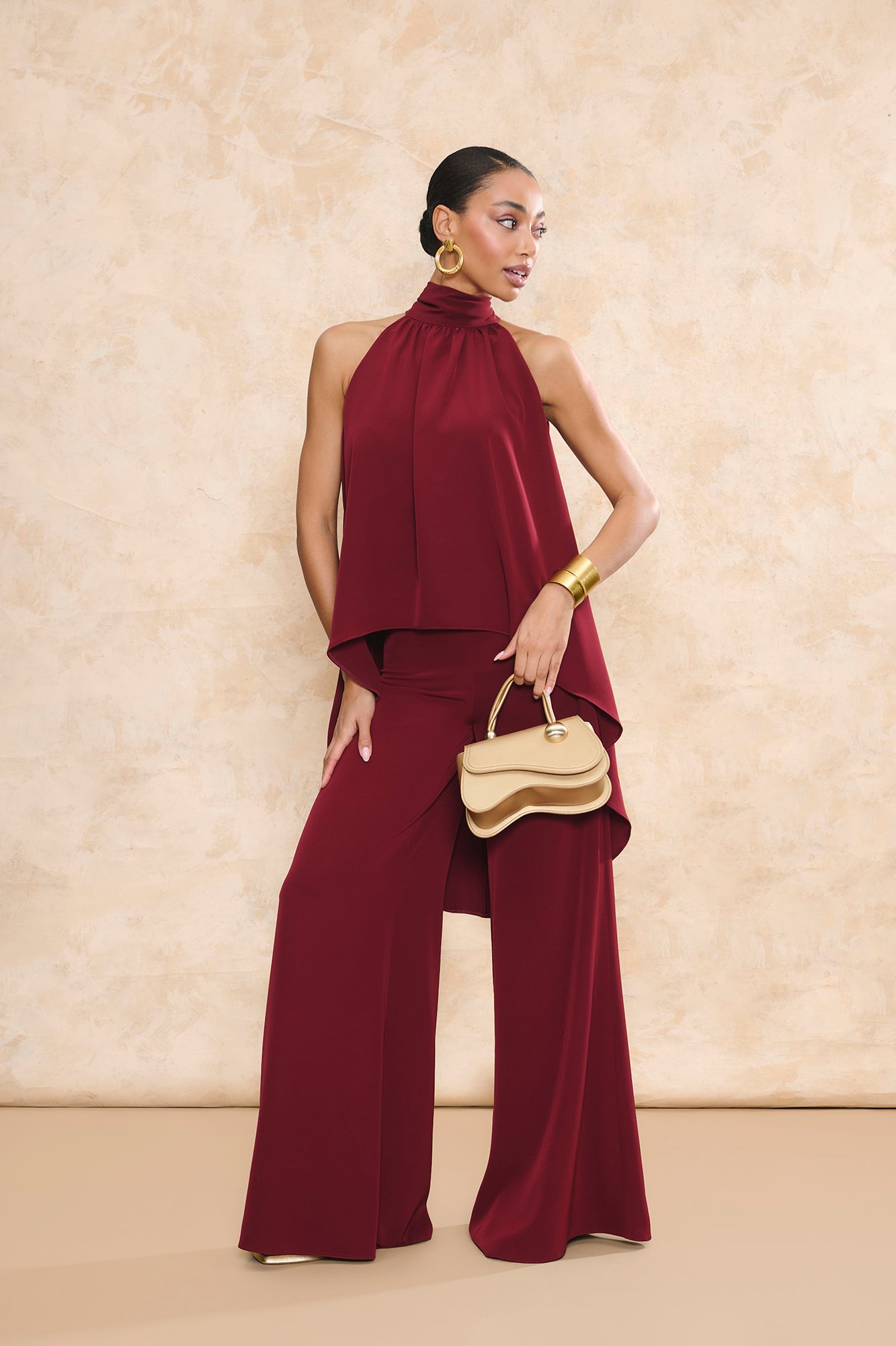 Conjunto Triana granate de pantalón de invitada palazzo y top halter asimétrico con caída fluida de Miphai.