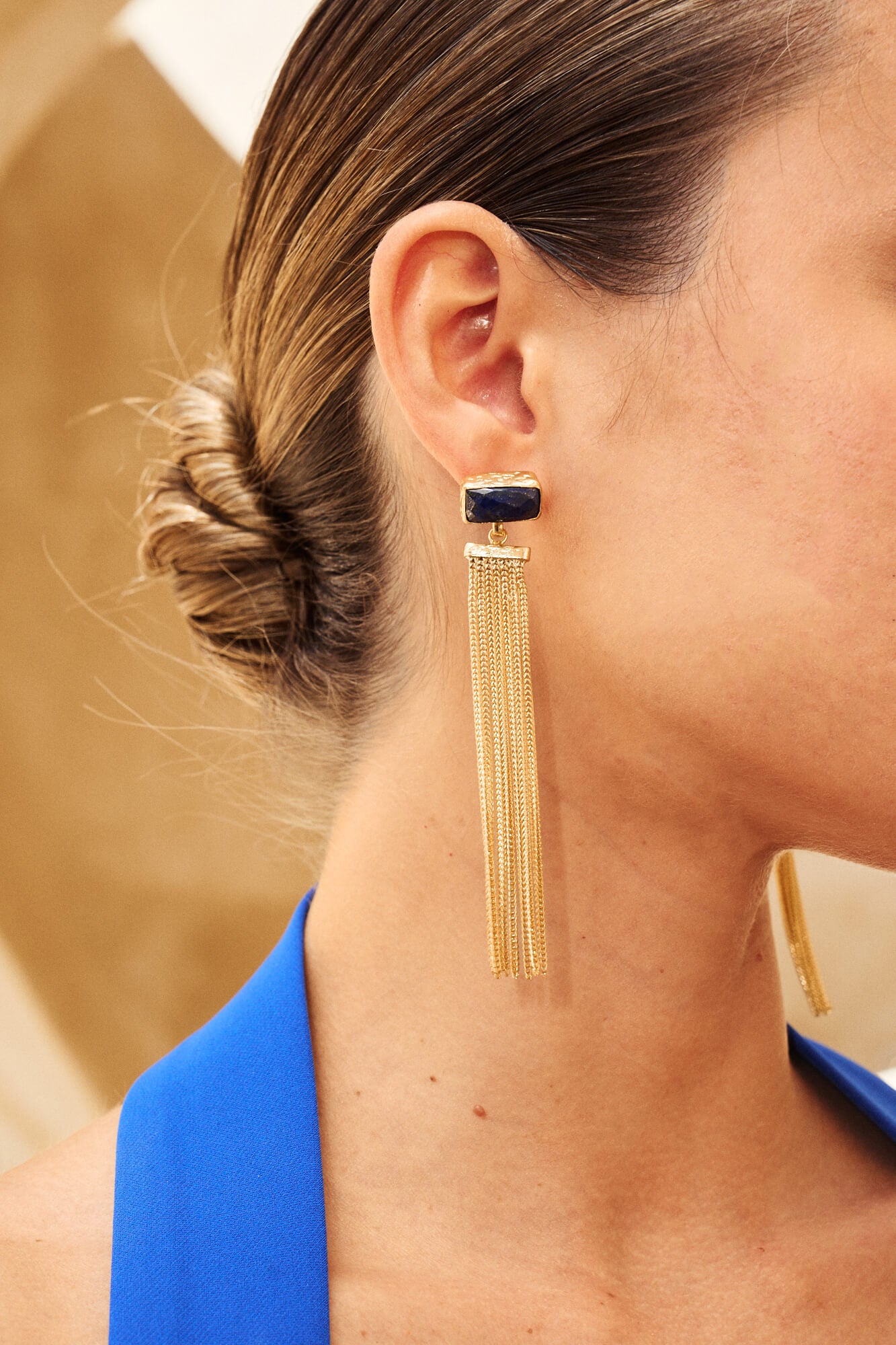 Pendientes largos Dione con piedra azul y cadenas doradas.