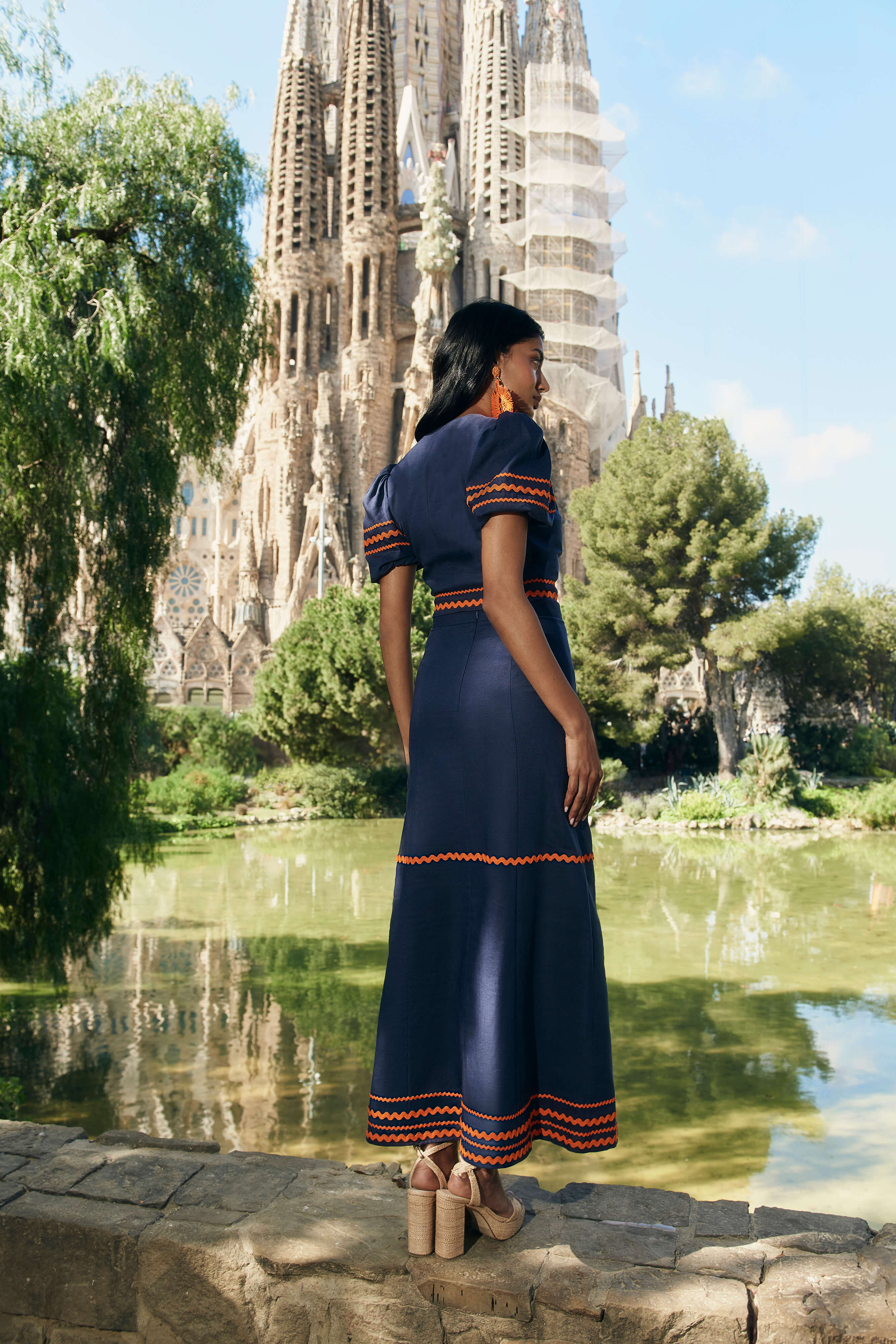 Top cruzado en lino azul marino con botones laterales, mangas abullonadas y cintas naranjas