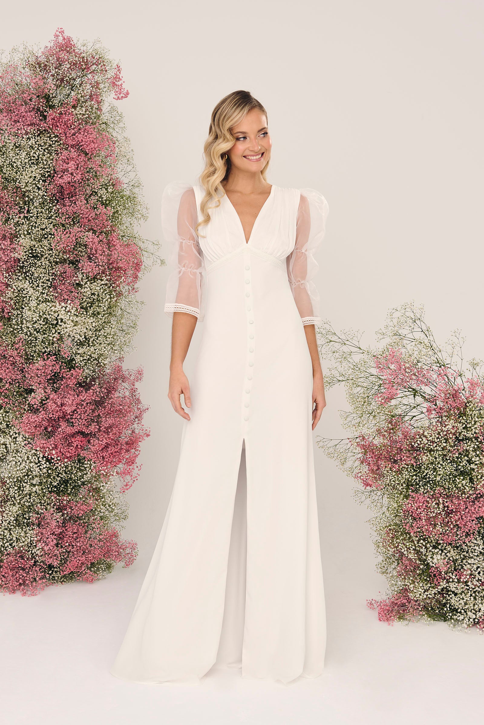 Vestido de novia Lavanda, escote en pico, mangas de organza, línea de botones frontales y abertura delantera.