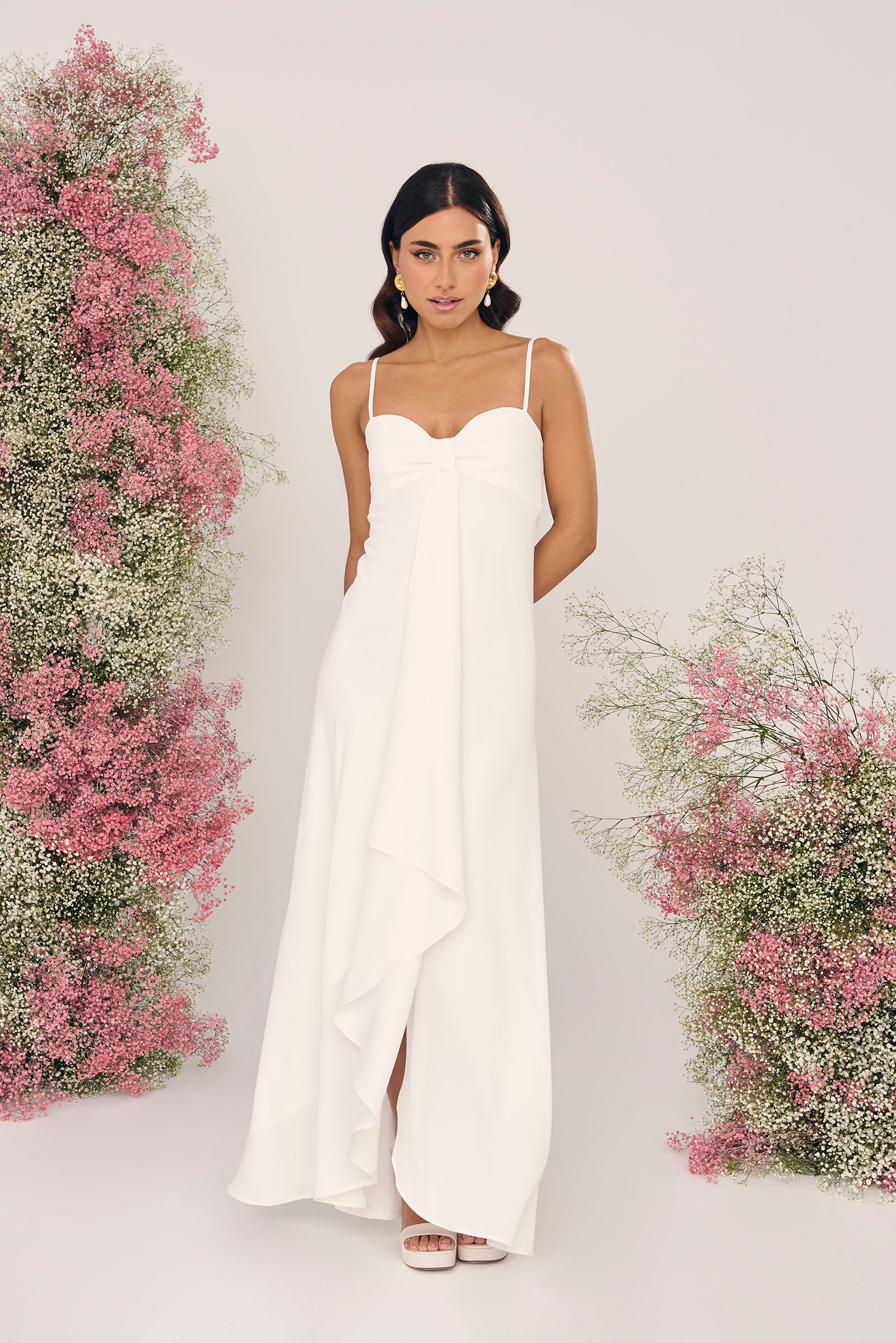 Vestido de novia Peonia en crepé satén blanco, con escote drapeado, tirantes finos y volante que cae hasta el suelo