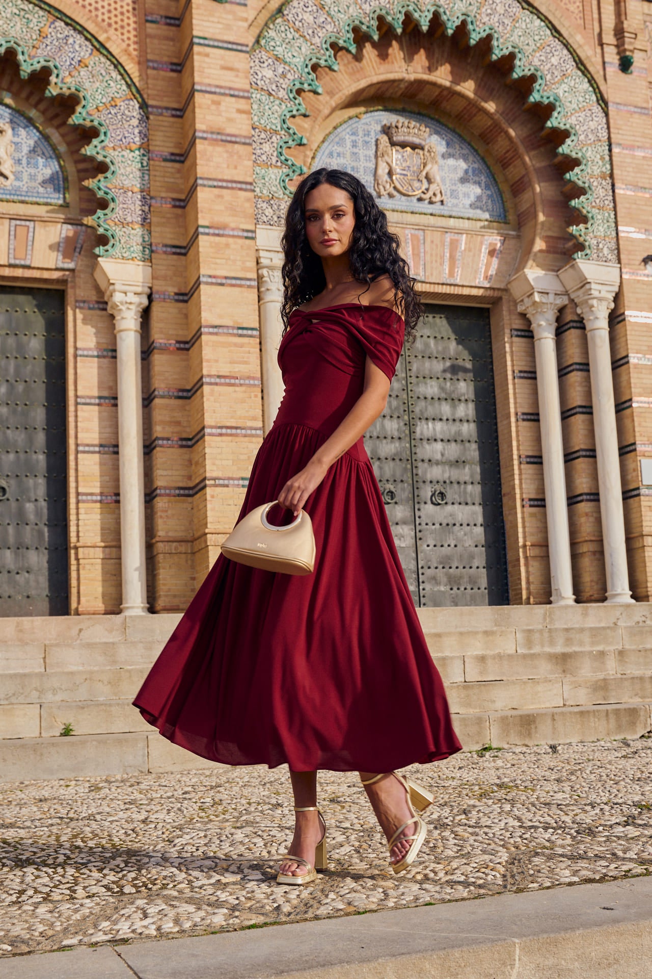Vestido Cayetana Midi en punto de seda granate, con escote palabra de honor y corte asimétrico.