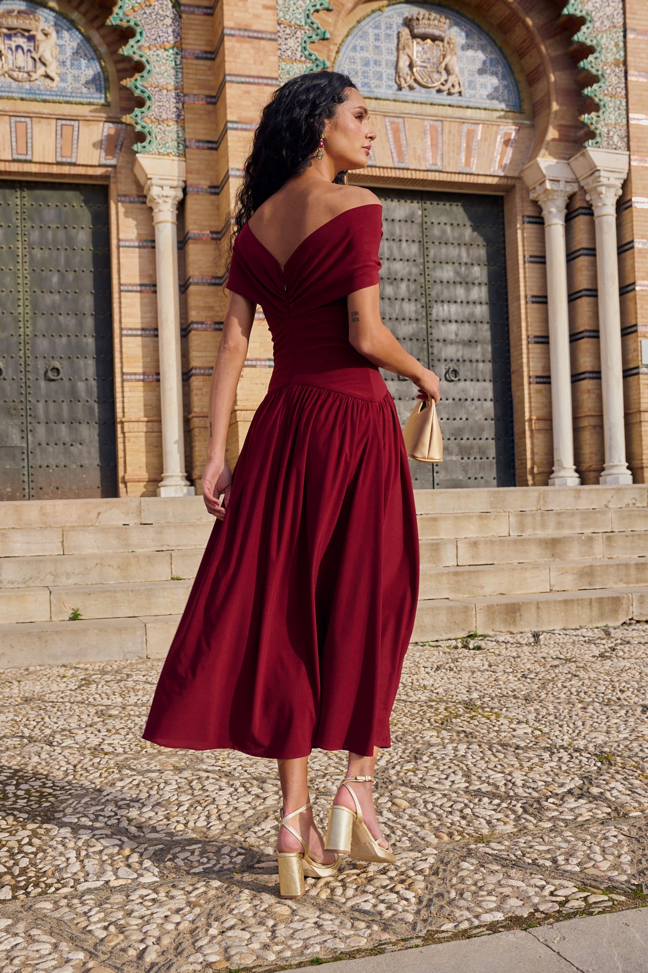 Vestido Cayetana Midi en punto de seda granate, con escote palabra de honor y corte asimétrico.