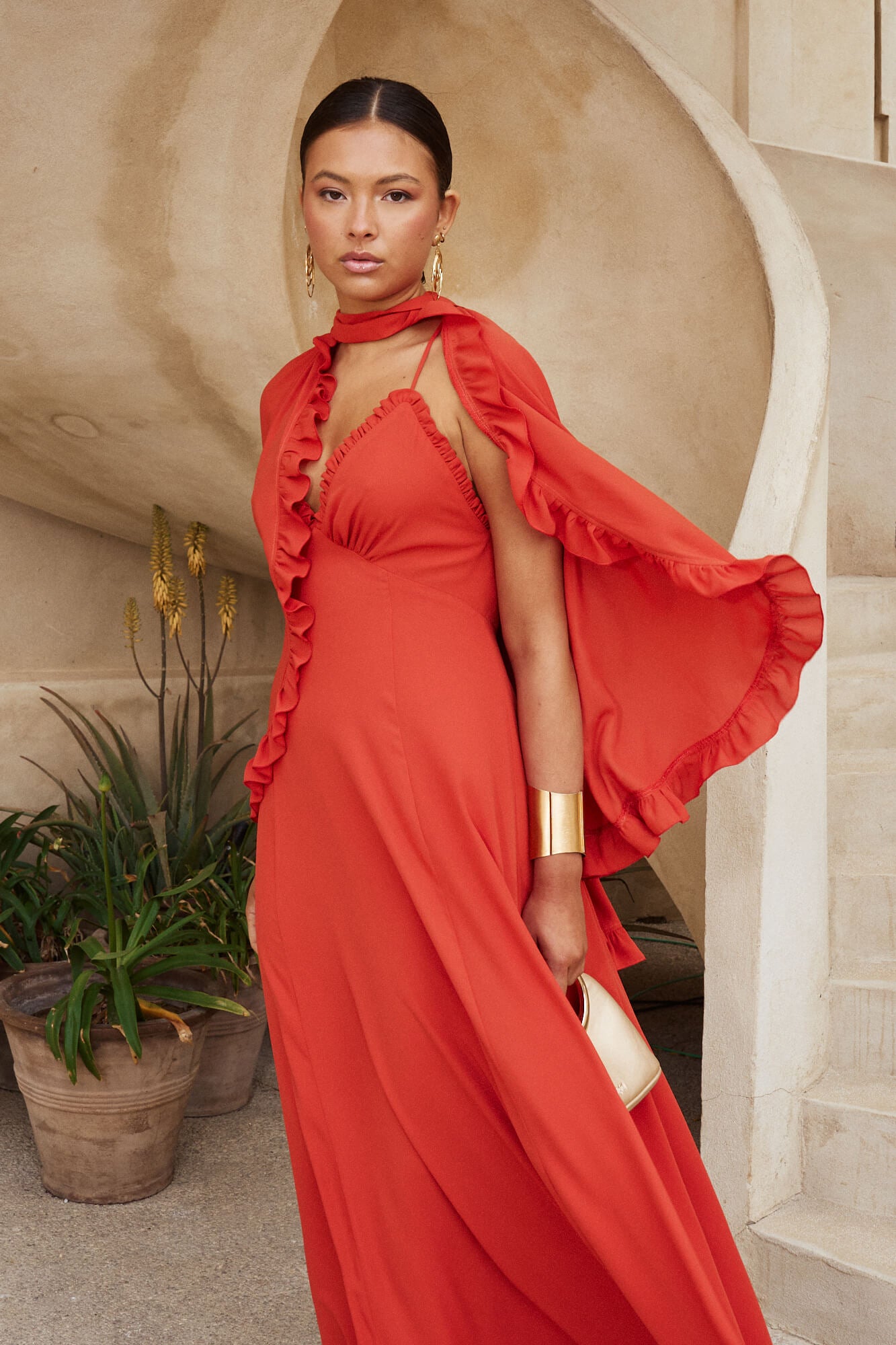 Descubre el Vestido Dana Largo en color caldera, con escote en V, espalda cruzada y volante.