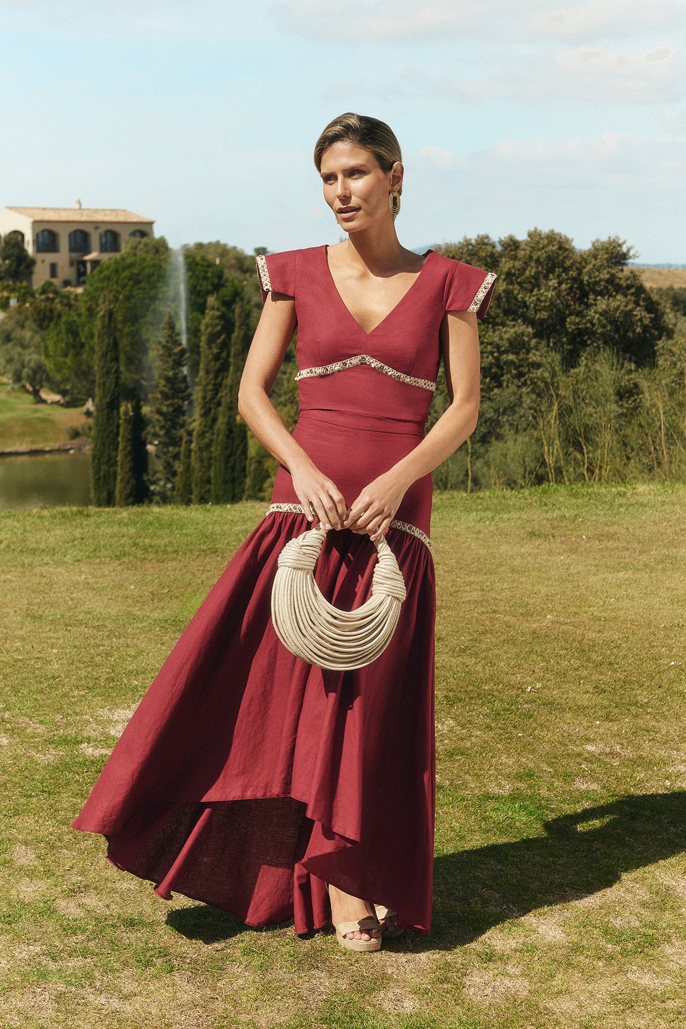 Miphai Falda Mambo color Cereza. Cintura alta. Ajustado hasta la cadera. Detalles ornamentales. Volante fruncido grande. Corte asimétrico. Plano con complemento; bolso Casia.