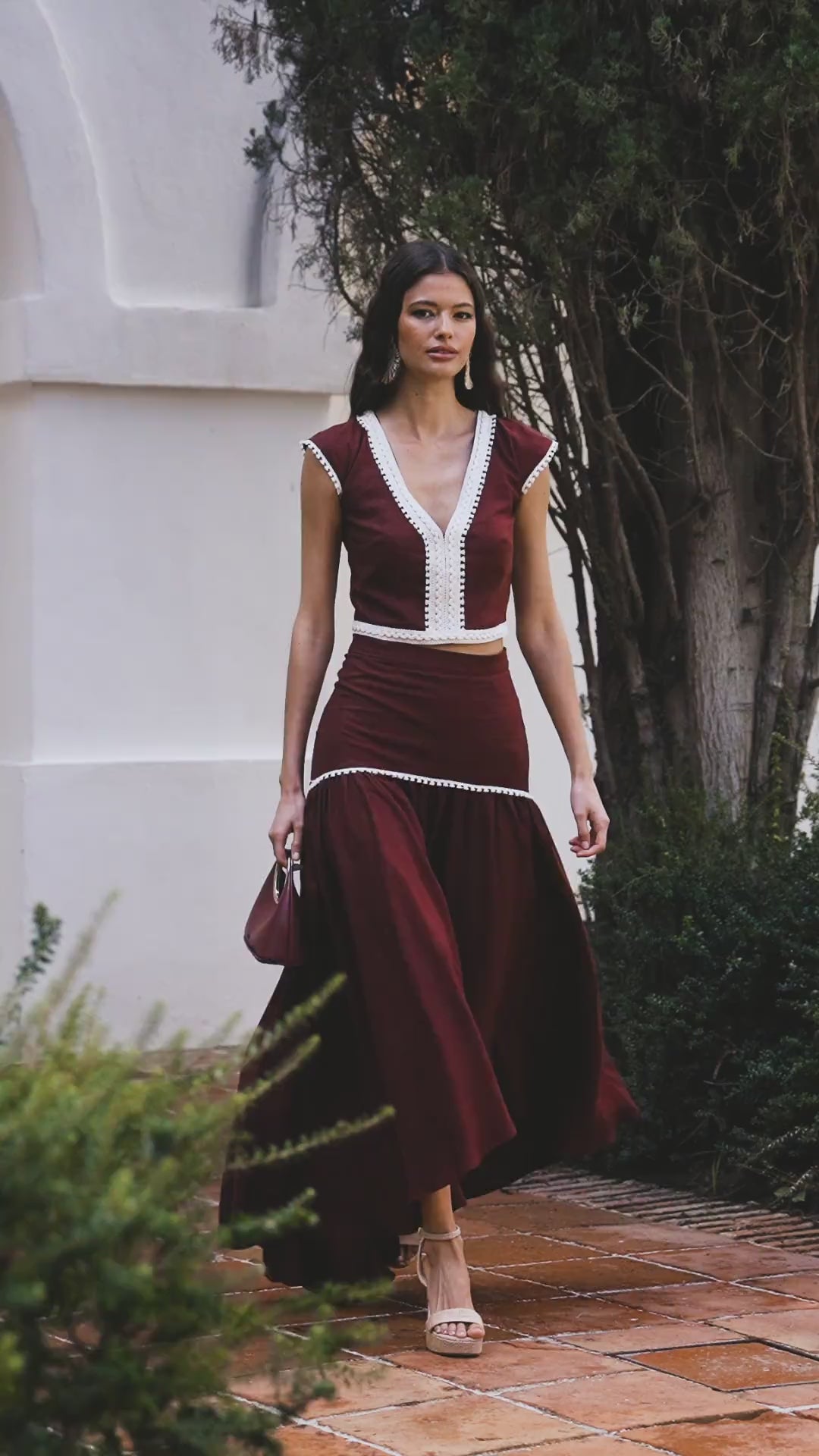 Falda Mambo Granate en lino , con corte asimétrico, cinta bolilla con flecos y cremallera trasera